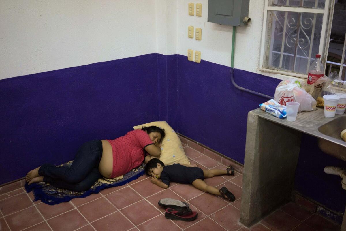 Una mujer embarazada y su hijo descansan en un refugio mientras esperan a que pase el huracán Patricia, en la ciudad turística de Puerto Vallarta, México, el viernes 23 de octubre de 2015. (AP Foto/Cesar Rodriguez)