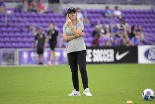 Orlando Pride head coach Amanda Cromwell watches players warm up before an NWSL Challenge Cup.