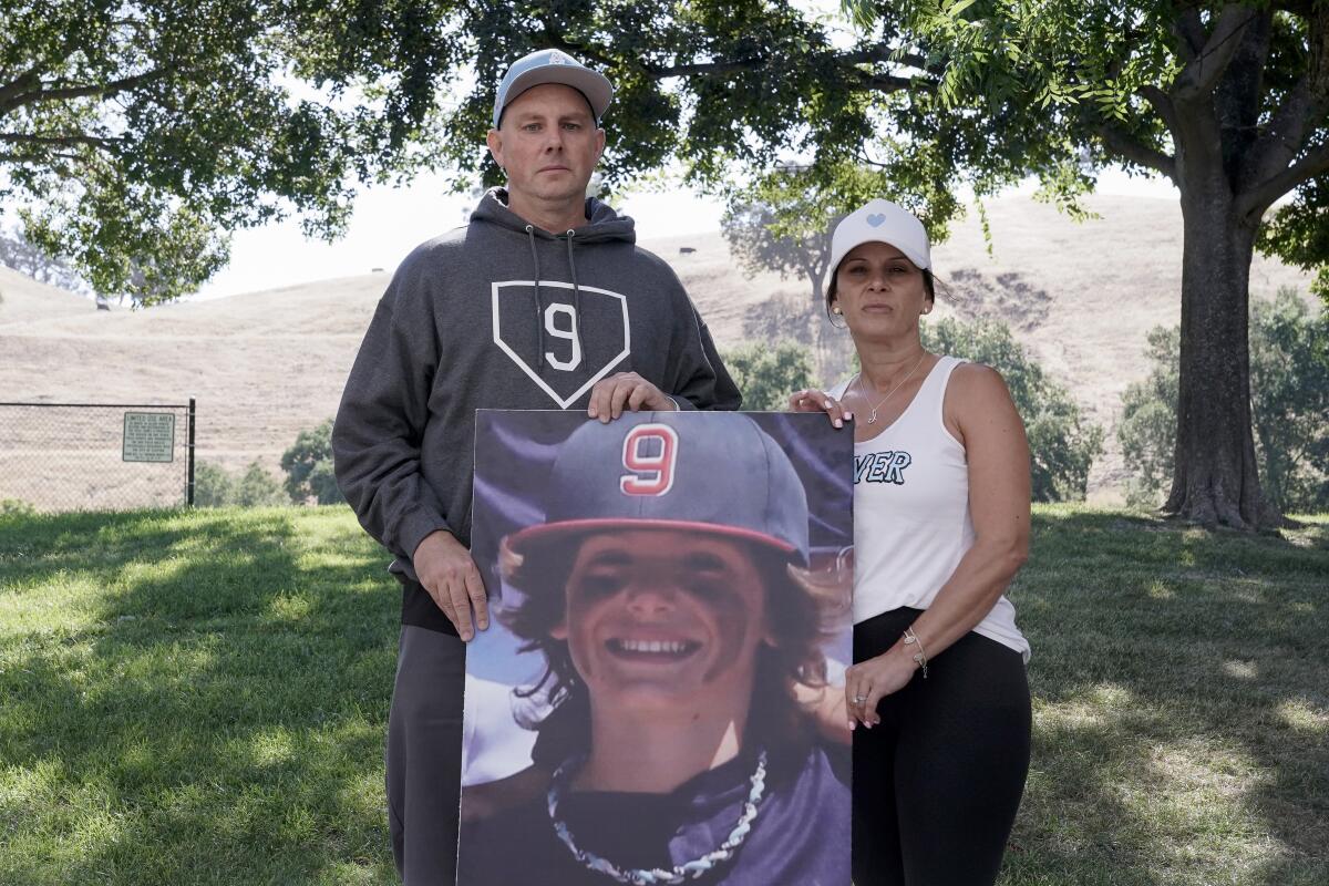 Padrig and Gina Fahey hold a photo of their son, Braden, who died of a malformed blood vessel in the brain. 