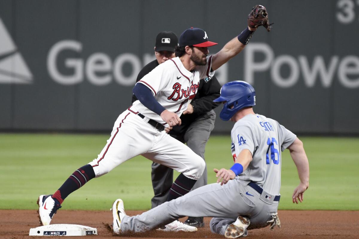 Atlanta Braves shortstop Dansby Swanson, left, forces out Will Smith at second during the first inning.