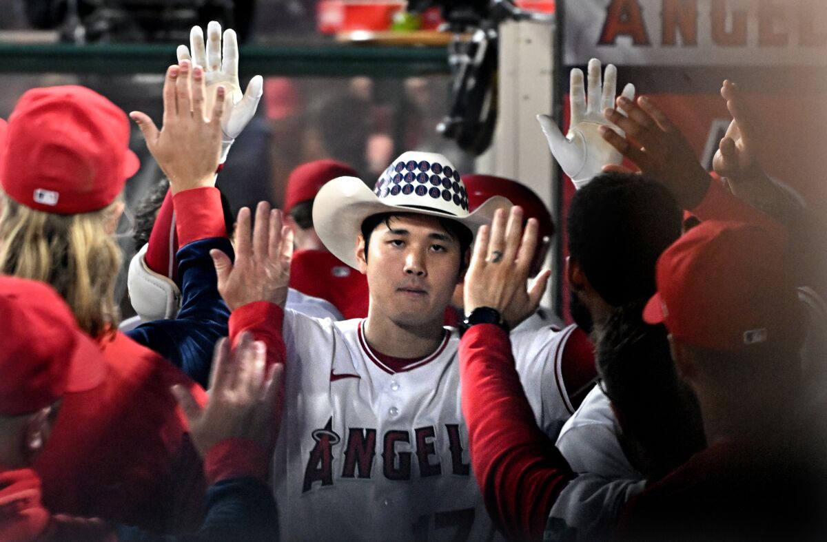 Angels pitcher Shohei Ohtani is congratulated in the dugout after hitting a two-run home run against the Boston Red Sox.