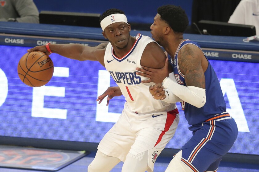 Clippers guard Reggie Jackson handles the ball while pressured by Knicks guard Elfrid Payton on Jan. 31, 2021, in New York.