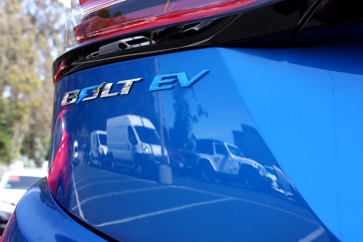 A logo is displayed on a Chevrolet Bolt EV that sits on the sales lot at Stewart Chevrolet on April 25, 2023 