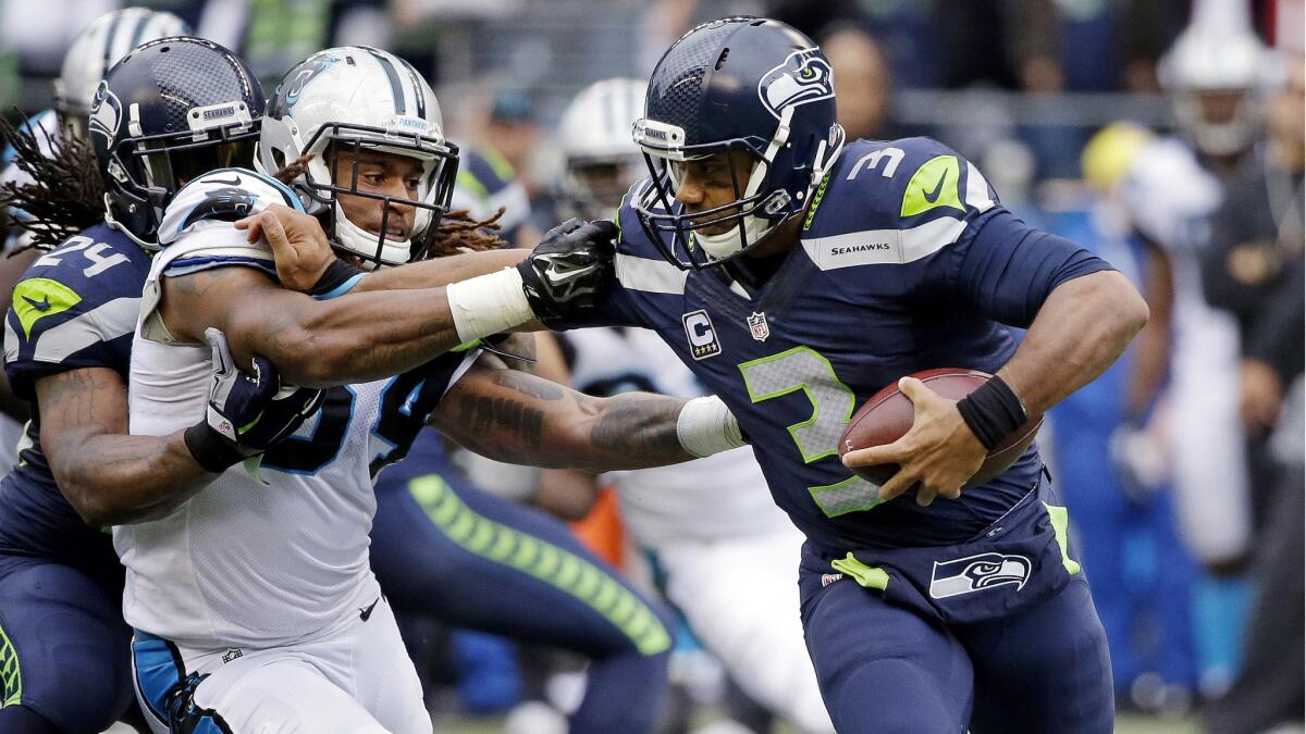 Seahawks quarterback Russell Wilson (3) has been on the run this season, including Sunday when Panthers linebacker Shaq Thompson broke through the line and past running back Marshawn Lynch.