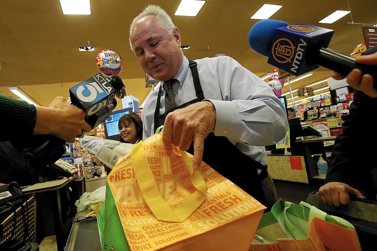 Outgoing Los Angeles City Councilman Tom LaBonge bags groceries at a Pavilions in December 2013. The two spots in the runoff race to replace him are still undecided.