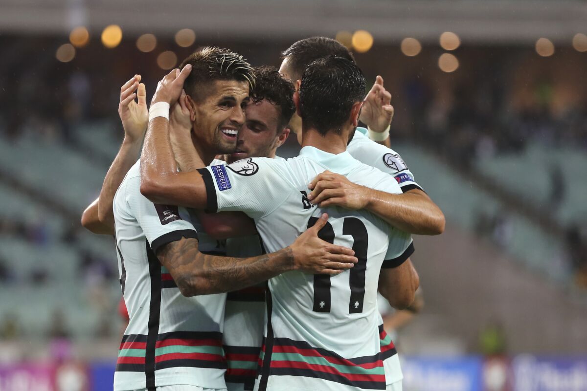 Portugal players celebrate after Portugal's Diogo Jota scored his side's third goal during the World Cup 2022 group A qualifying soccer match between Azerbaijan and Portugal at the Olympic stadium in Baku, Azerbaijan, Tuesday, Sept. 7, 2021. (AP Photo/Aziz Karimov)