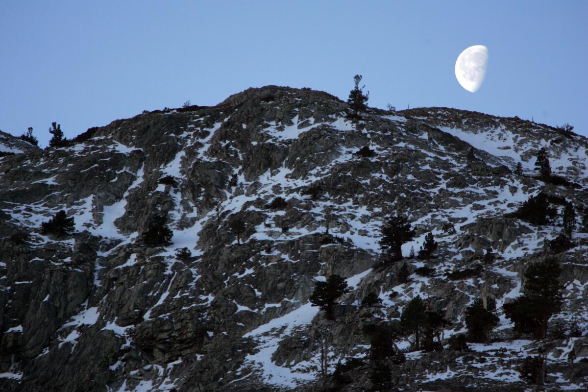 A moon rising over a mountain.