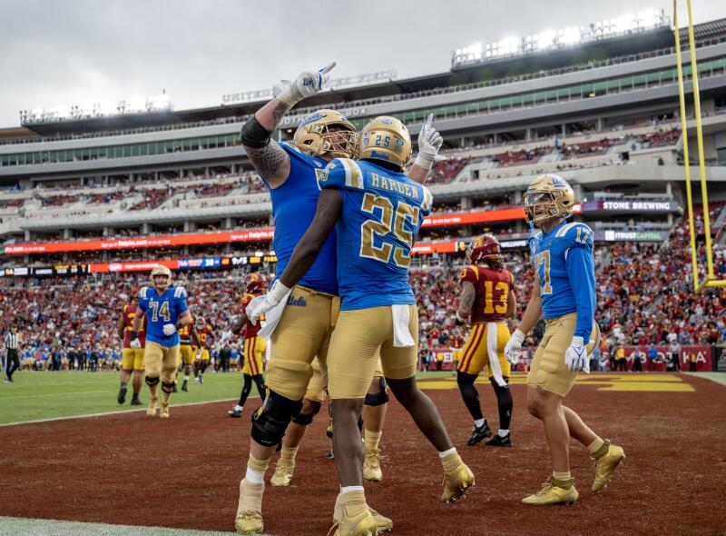 UCLA running back T.J. Harden (25) celebrates with UCLA offensive lineman Josh Carlin after scoring a touchdown against USC.