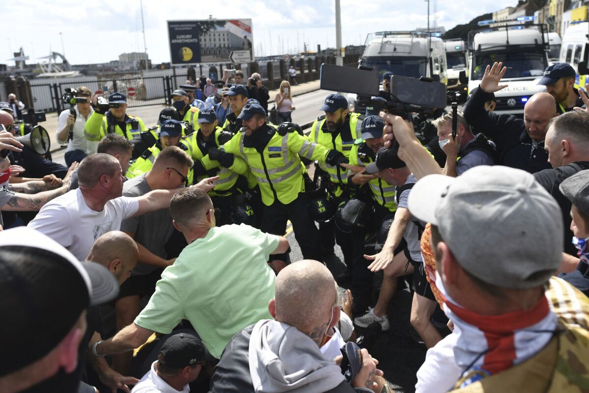 Anti-migrant protesters react with police, in Dover, England, Saturday, Sept. 5, 2020. Police controlled a small scale demonstration against immigration, calling for authorities to do more to protect English shores, at England's southern port city nearest to mainland Europe. (Stefan Rousseau/PAvia AP)