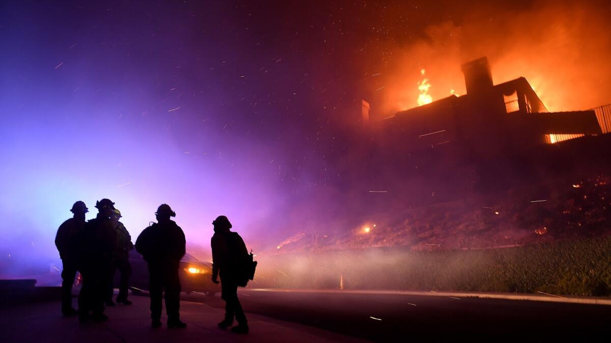 Firefighters monitor a house fully engulfed on Mountain Crest Circle in Thousand Oaks early Nov. 9. The Woolsey fire destroyed more than 1,600 structures in L.A. and Ventura counties, many of which were homes.