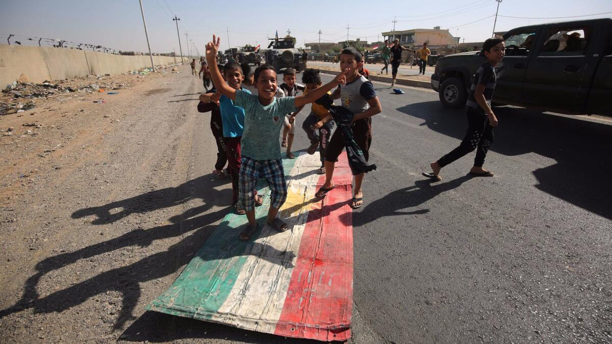 Iraqi children step on a Kurdish flag as forces advance toward the center of Kirkuk, Iraq, during an operation against Kurdish fighters on Oct. 16, 2017.