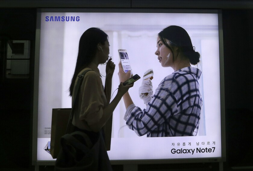 A woman walks by an advertisement for Samsung's Galaxy Note 7 smartphone at a subway station in Seoul in September.