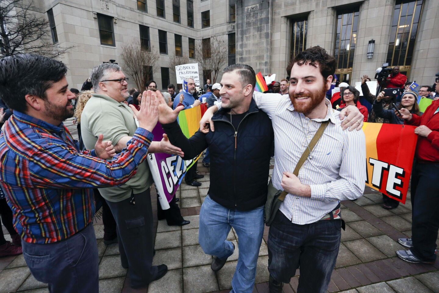 Newly married couple David Roby, center, and Erik Obermiller are cheered by supporters as they leave the Jefferson County courthouse in Birmingham.