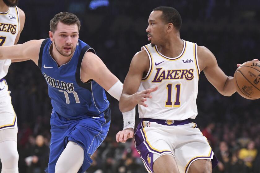 Dallas Mavericks guard Luka Doncic (77) defends Los Angeles Lakers guard Avery Bradley (11) during the first half of an NBA basketball game Sunday, Dec. 29, 2019, in Los Angeles. (AP Photo/Michael Owen Baker)