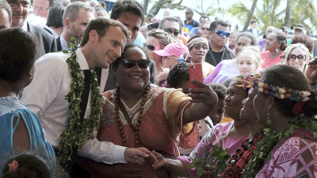 French President Emmanuel Macron poses for a selfie while meeting residents as part of a remembrance ceremony on Ouvea Island, in the archipelago of New Caledonia, in May. New Caledonia will vote on its independence from France on Sunday.