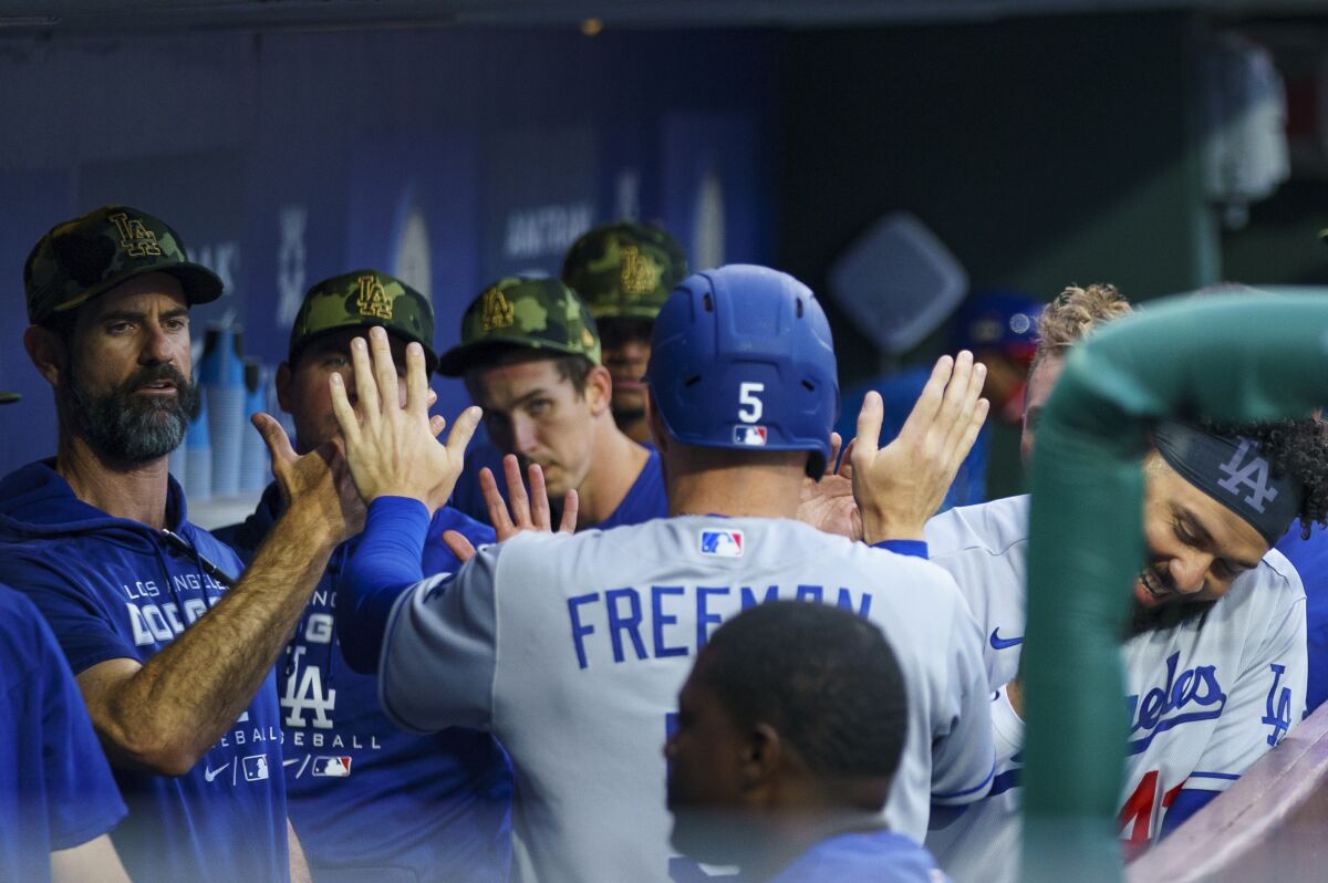 Dodgers first baseman Freddie Freeman, center, celebrates in the dugout after scoring against the Phillies.