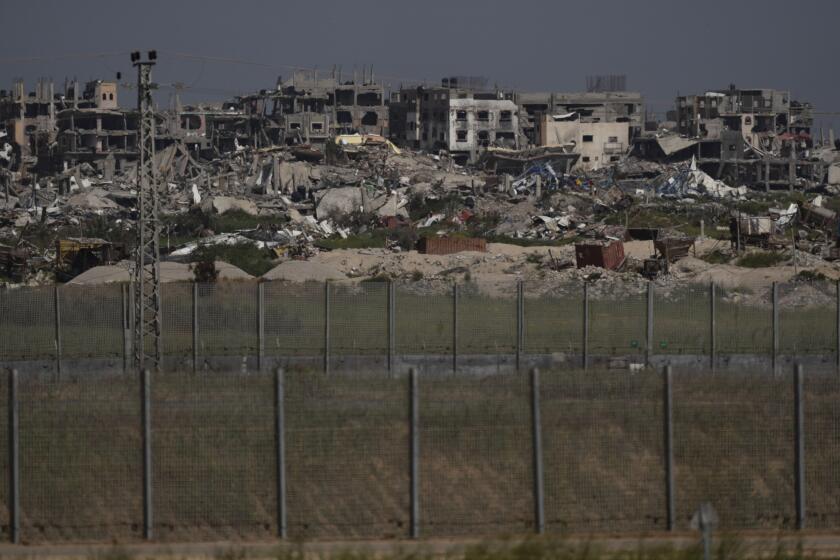 Destroyed buildings stand in the Gaza Strip as seen from southern Israel, Thursday, March 28, 2024. (AP Photo/Leo Correa)