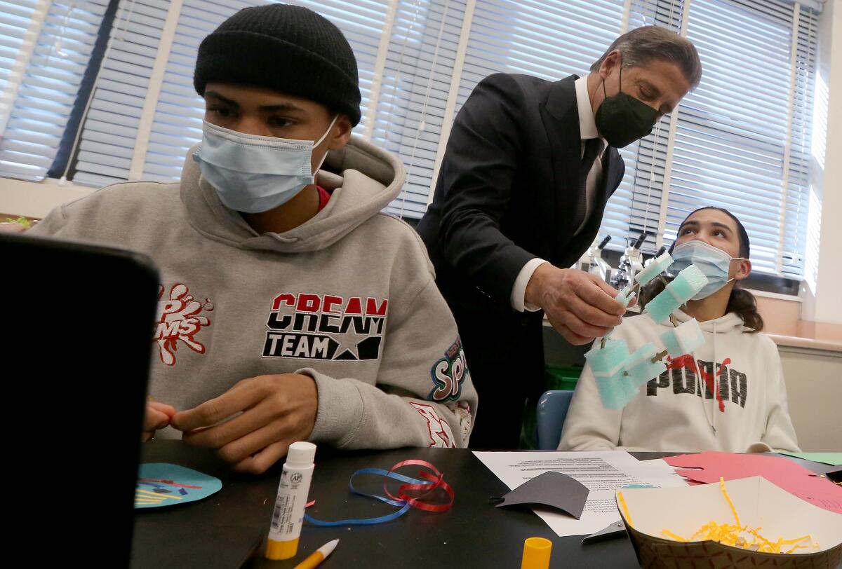 L.A. schools Supt. Alberto Carvalho wears a mask to talk to masked students.