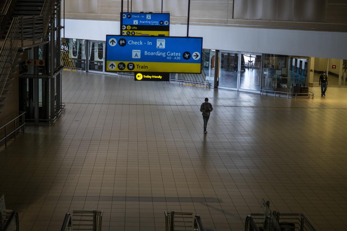 Un hombre camina el lunes 29 de noviembre de 2021 por una terminal desierta del aeropuerto 