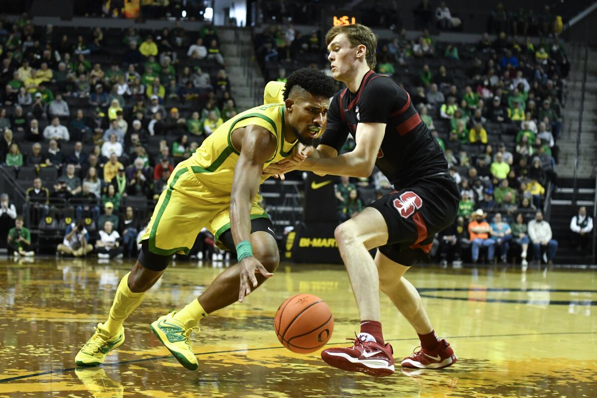 Oregon forward Quincy Guerrier, left, is fouled by Stanford forward Max Murrell.