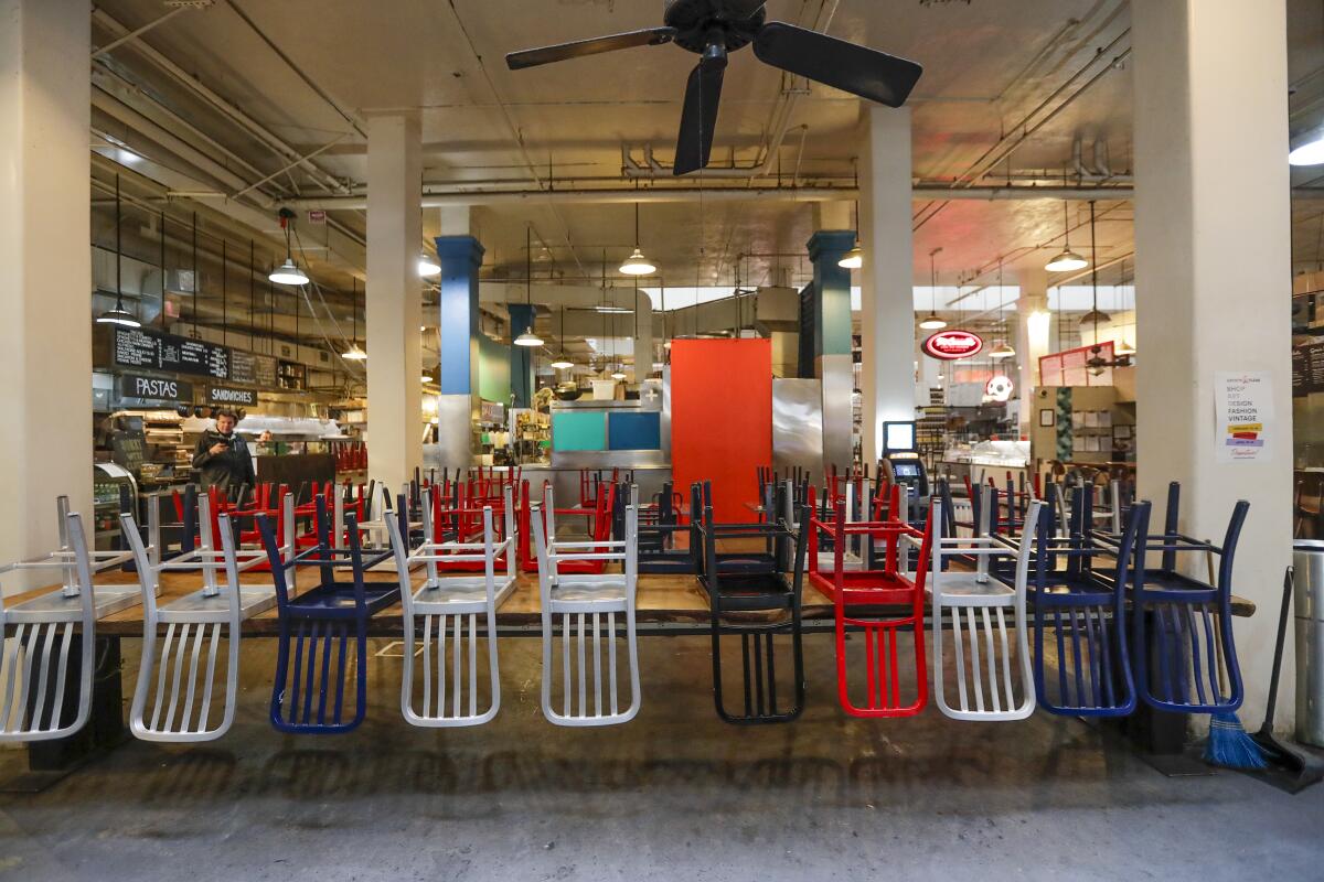 Upturned chairs at L.A.'s Grand Central Market, where takeout has continued during the lockdown but seating is banned.