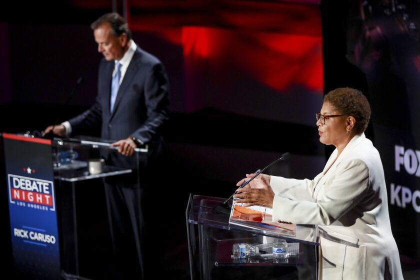 Los Angeles, CA - September 21: Rep. Karen Bass, right, speaks as developer Rick Caruso listens during the Los Angeles mayoral debate ahead of the Nov. 8 general election at the Skirball Cultural Center in Los Angeles, Wednesday, Sept. 21, 2022. The Los Angeles Times, Fox 11 LA, Univision 34, KPCC, the Skirball Cultural Center, the Los Angeles Urban League and Loyola Marymount University co-host back-to-back debates with the leading candidates in the L.A. mayoral and L.A. County Sheriff races. Los Angeles County Sheriff debate includes Sheriff Alex Villanueva and retired Long Beach Police Chief Robert Luna. The evening aims to be informative for Angelenos ahead of the Nov. 8 general election, which will include the runoff for the next mayor and sheriff. The debates will be co-moderated by Times Columnist Erika D. Smith and Fox 11 News Anchor Elex Michaelson. Additionally, Univision morning news anchor Gabriela Teissier will join the moderators during the mayoral debate, and Univision evening news anchor Oswaldo Borraez will join the moderators during the sheriff candidates debate. KPCC criminal justice correspondent Frank Stoltze will contribute as well.(Allen J. Schaben / Los Angeles Times)