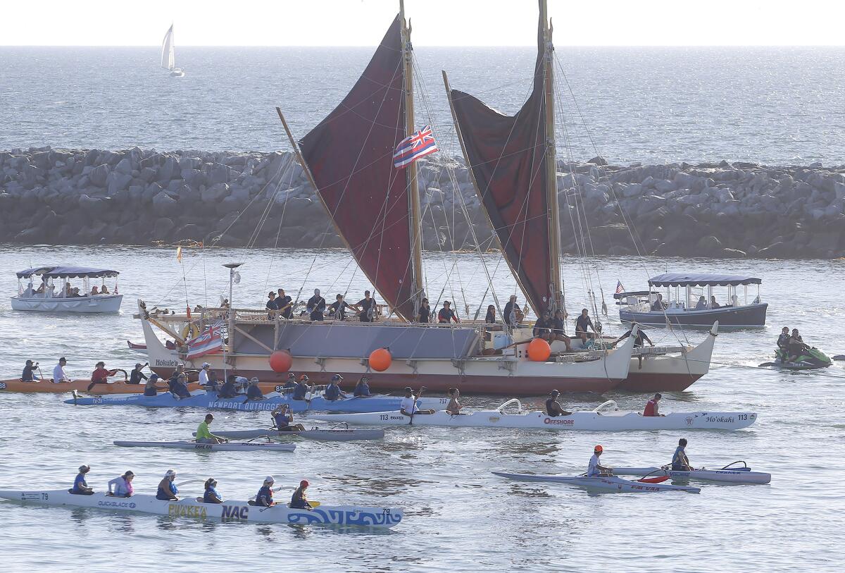 The Hawaiian canoe Hokule‘a is escorted by local outrigger club boats during a traditional ceremony Monday in Newport Harbor.