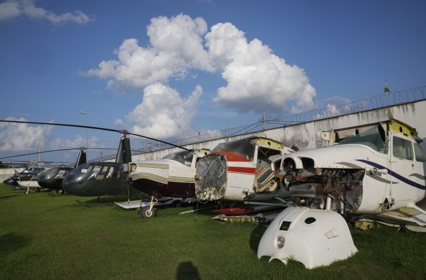 Planes and helicopters seized for allegedly being connected to illegal gold mining activity sit in the backyard of the Federal Police headquarters in Boa Vista, Roraima state, Brazil, Wednesday, Nov. 3, 2021. Generally, the illegal aircraft owners are local elites who launder their money in Boa Vista hotels, restaurants, gyms and gasoline stations, according to the police, which declined to disclose names.(AP Photo/Andre Penner)