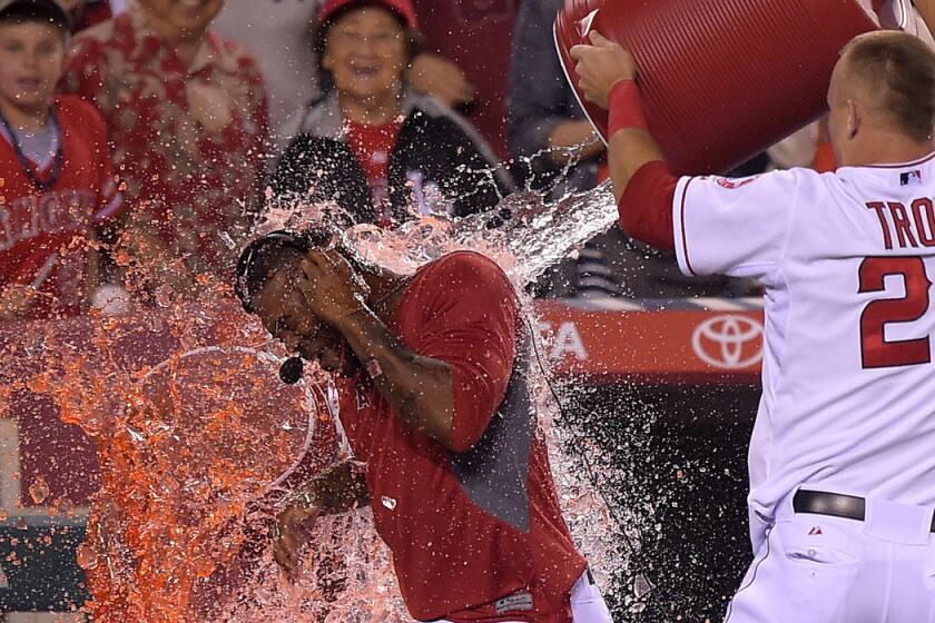 Angels outfielder Mike Trout gives second baseman Howie Kendrick a victory shower during his postgame interview Saturday night in Anaheim.
