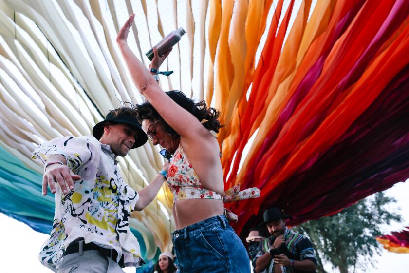Indio, CA - April 12: Brandon and Kari Bulat dance together at Do LaB on the first day at the Coachella Valley Music and Arts Festival on Friday, April 12, 2024 in Indio, CA. (Dania Maxwell / Los Angeles Times)