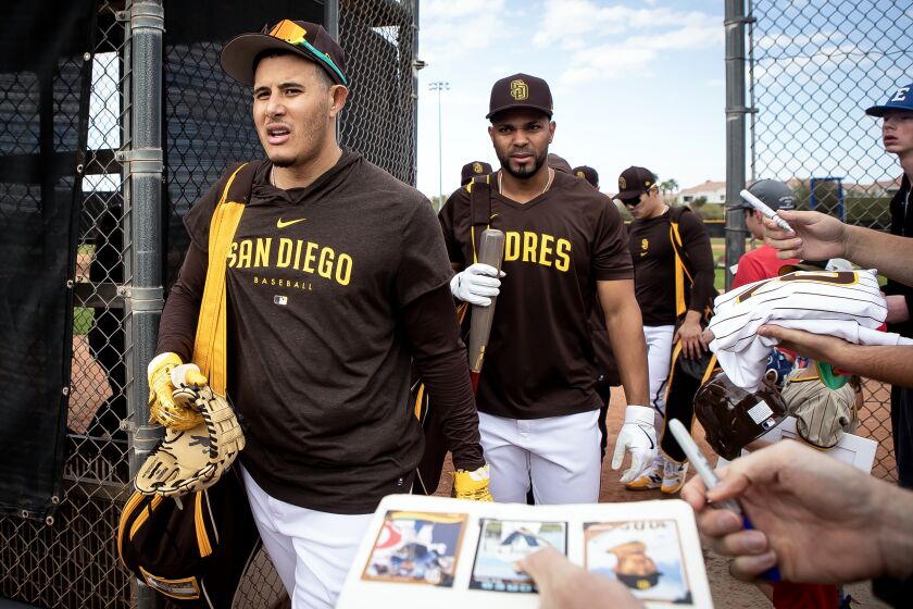 Peoria, AZ - February 21: Padres third baseman Manny Machado (13) and shortstop Xander Bogaerts (2) and shortstop Ha-Seong Kim (7) exit the field as fans beg for autographs during a spring training practice at the Peoria Sports Complex on Tuesday, Feb. 21, 2023 in Peoria, AZ. (Meg McLaughlin / The San Diego Union-Tribune)