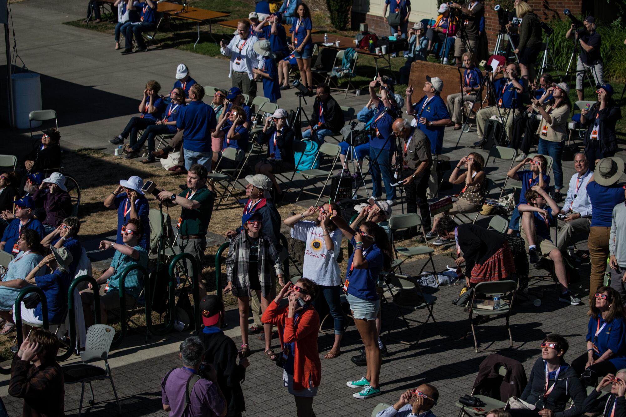 2017 年 8 月 21 日，俄勒冈州塞勒姆，一群人抬头观看日食。 