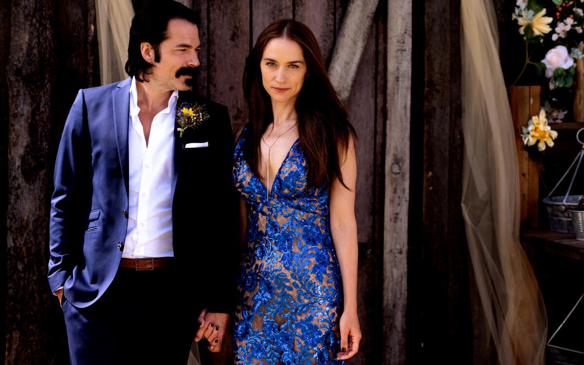 A man and a woman holding hands in formalwear