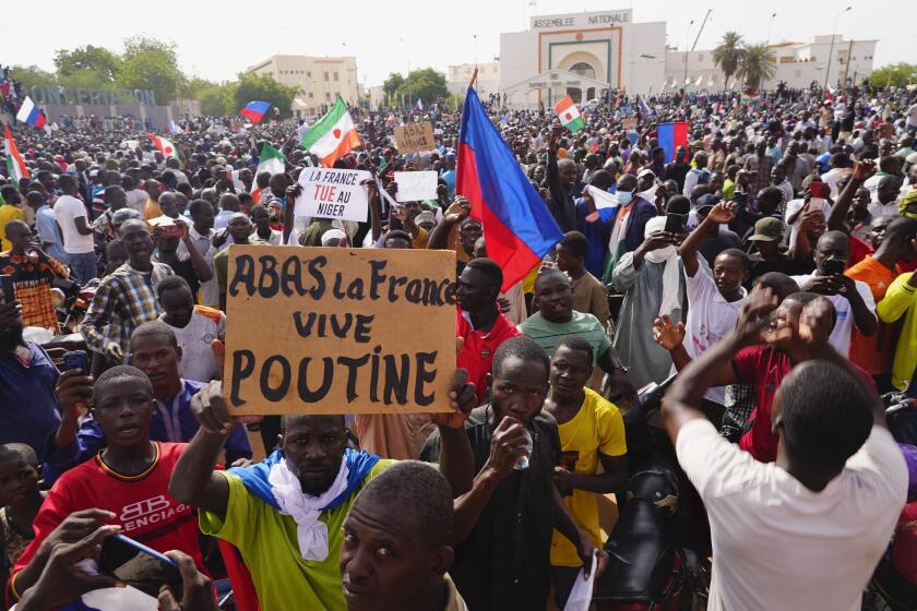 FILE - Nigeriens participate in a march called by supporters of coup leader Gen. Abdourahmane Tchiani in Niamey, Niger, Sunday, July 30, 2023. The French Foreign Ministry says Tuesday, Aug.1, 2023 France is planning an imminent evacuation of people seeking to leave Niger after the coup last week in the former French colony. Poster reads: Down with France, long live Putin." (AP Photo/Sam Mednick, File)