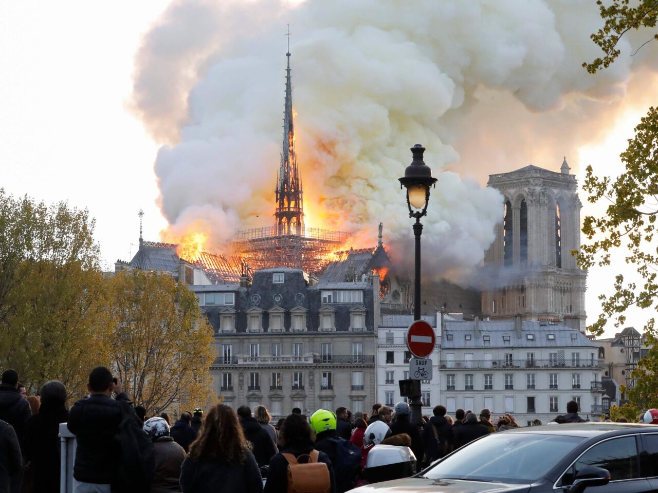 Seen from across the Seine River, smoke and flames rise from the fire at the landmark Notre Dame Cathedral.