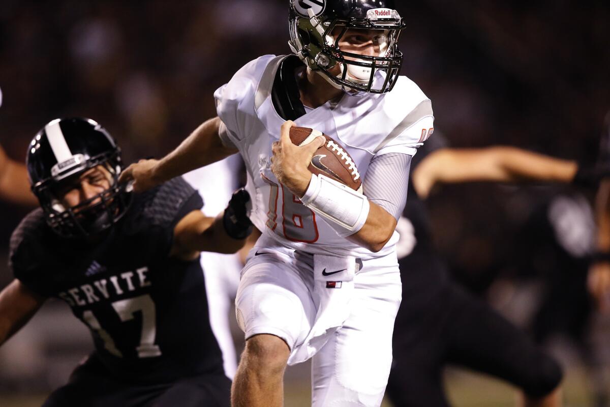 Las Vegas Bishop Gorman quarterback Tate Martell gets past Anaheim Servite linebacker Jack Savage last August.