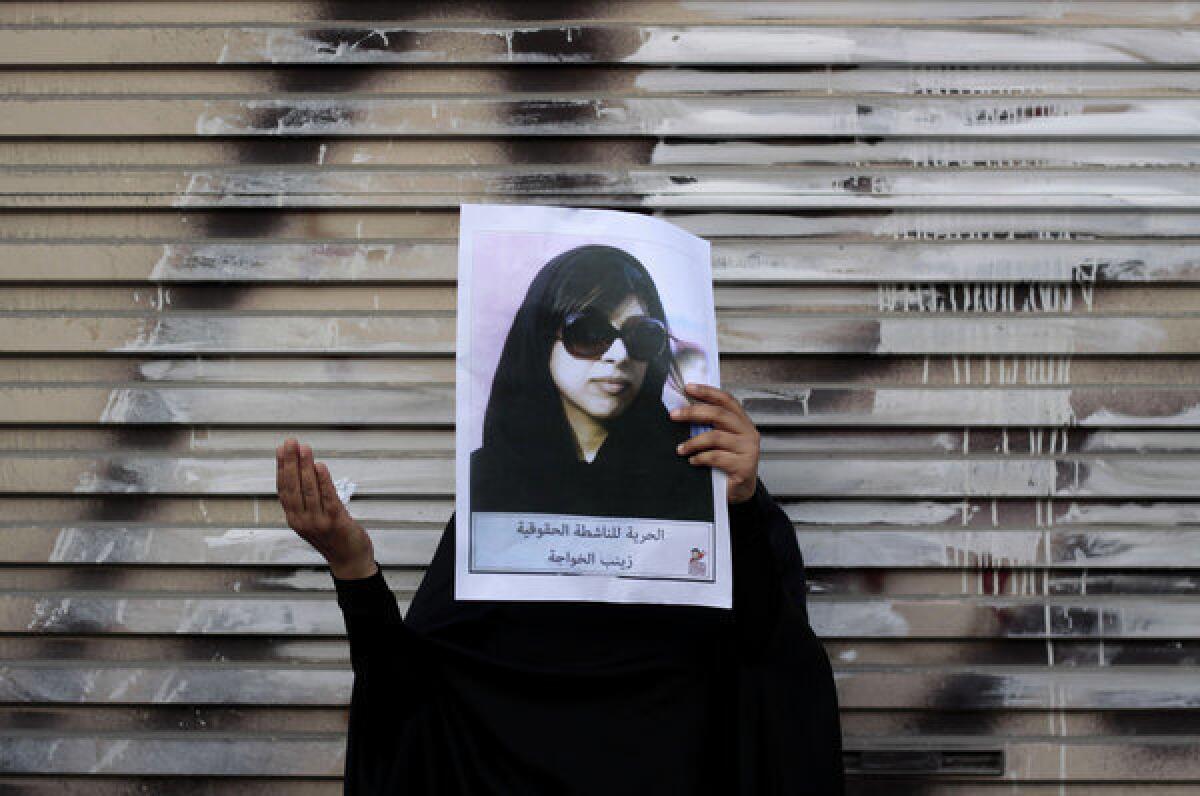 An antigovernment protester holds up a picture of jailed opposition human rights activist Zainab Khawaja after a march in Malkiya, Bahrain. The sign reads, "Freedom for rights activist Zainab Khawaja."