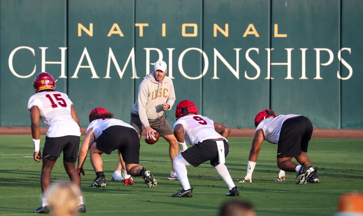 USC defensive coordinator Alex Grinch works with players during a team practice session Friday.