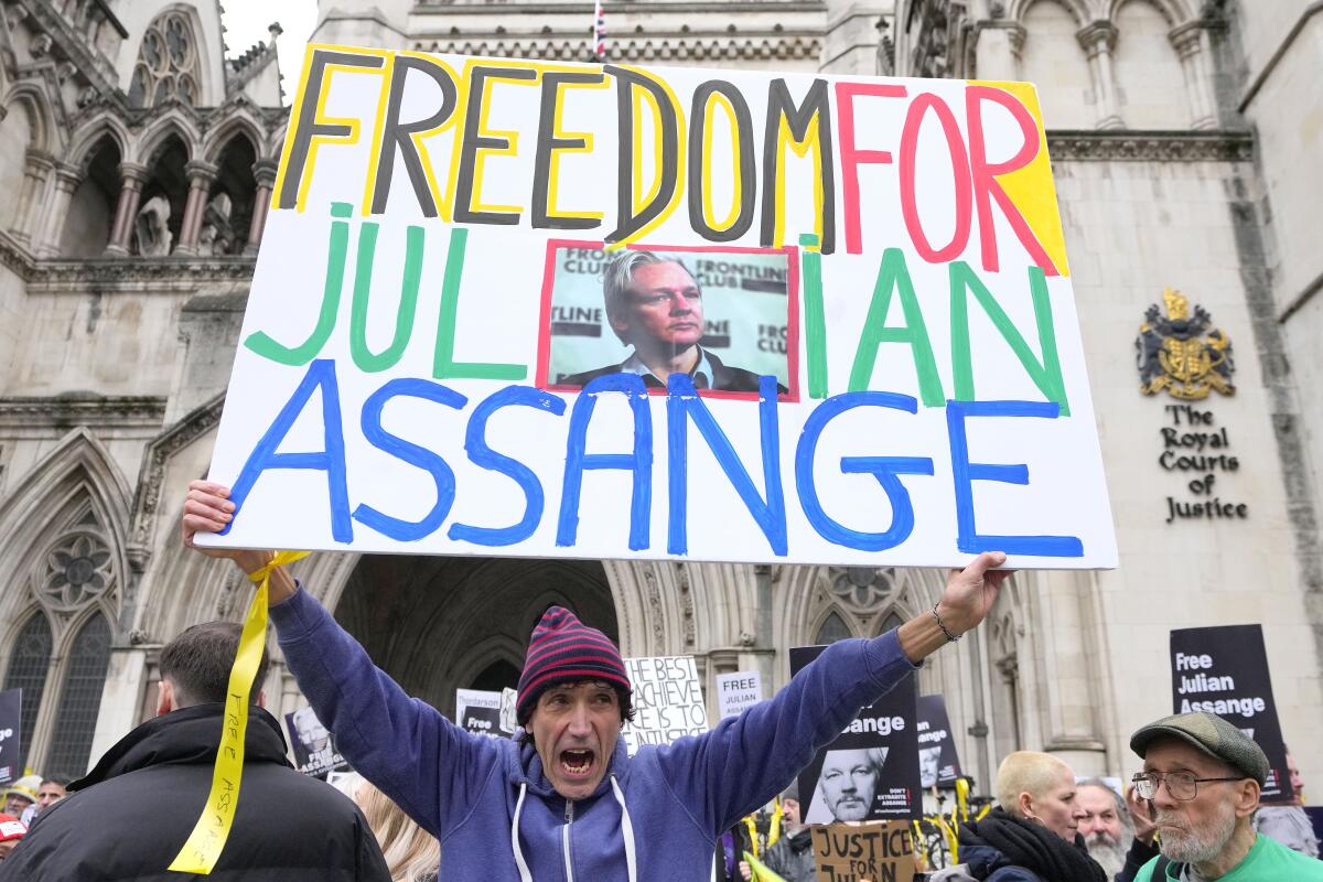 Demonstrators hold banners outside the Royal Courts of Justice in London.
