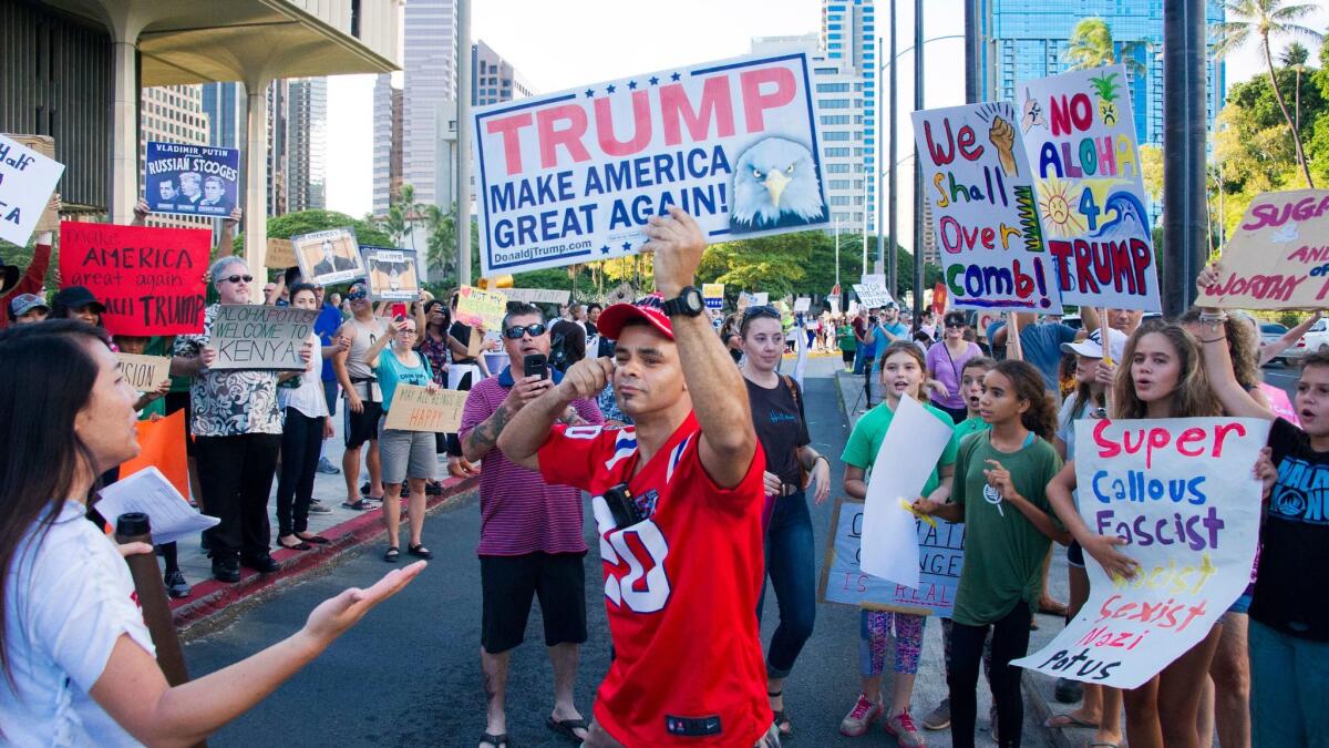 A Trump supporter holds a Make America Great Again sign in Honolulu on Nov. 3.